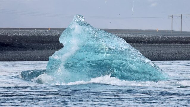 Big blocks of blue ice floating on Jokulsarlon lake in Iceland. Global warming leads to the melting of glaciers and the formation of glacial lakes with icebergs floating in them.