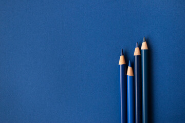 Blaue Buntstifte auf blauem Hintergrund. Freiraum für Text