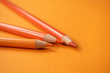 Orange Buntstifte auf orangem Hintergrund. Detail-Makroansicht