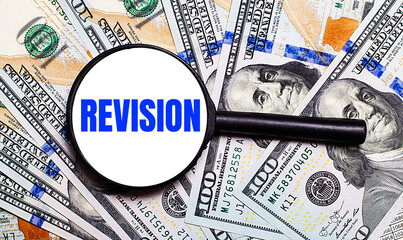Background with dollar bills under a magnifying glass with the text REVISION. Financial concept