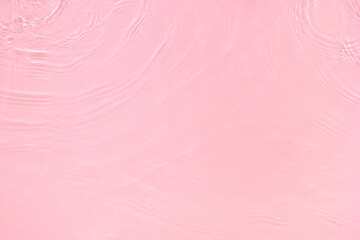 Transparent pink colored clear water surface texture with ripples, splashes and bubbles. Abstract...