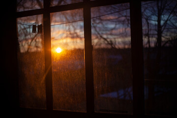 Dawn through the window. The sun rises behind the glass. Morning in autumn. T