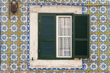 Fototapeta na wymiar Window at Lisbon house surrounded by Azulejos tiles