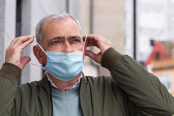 adult man putting the medical mask on his face