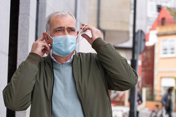 adult man putting the medical mask on his face