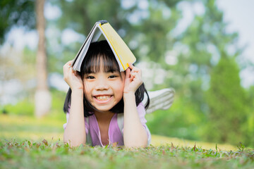 Image of Asian little girl studying at park