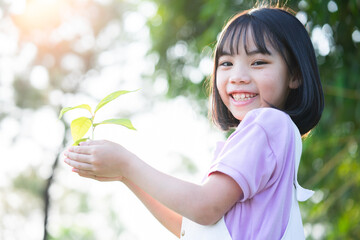 Image Asian little girl holding a sapling in her hand