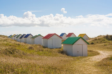 Fototapeta na wymiar Beach huts with colorful roofs at Gouville-sur-mer, France
