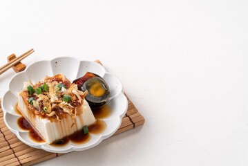 Delicious Chilled tofu and century egg with soy sauce and bonito flakes.
