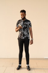 Portrait of handsome young African man using mobile phone
