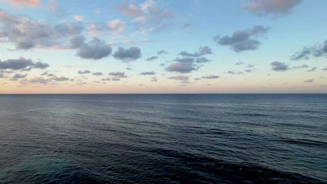 Flying over ocean at sunset