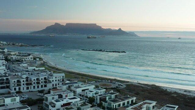View of Bloubergstrand and Blouberg Beach With the Lion's Head Mountain and Table Mountain in the Background in Cape Town, South Africa - Forward Panning Aerial Shot