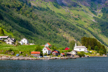 Traditional Norwegian small village with red wooden houses in Aurlandsfjord. Amazing beautiful view of the green mountains