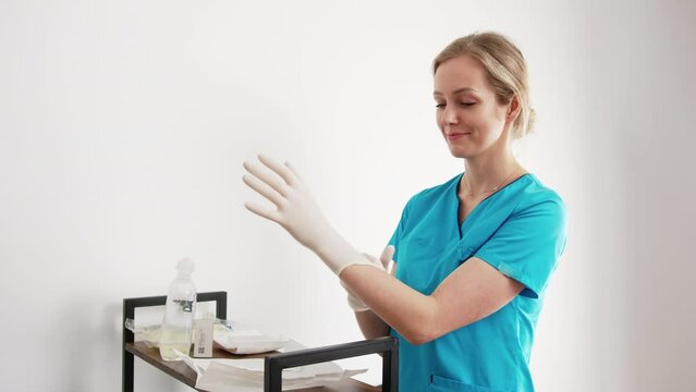 Female Caucasian Hygienist Or Nurse Preparing For Medical Procedure By Putting On White Protective Latex Gloves. High Quality 4k Footage