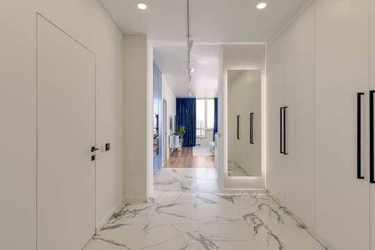 Bright entrance hall in a modern interior with marble floor and black fittings