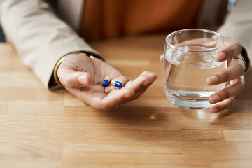 I hope these help. Cropped shot of an unrecognizable businesswoman taking pills with a glass of water while in her office.