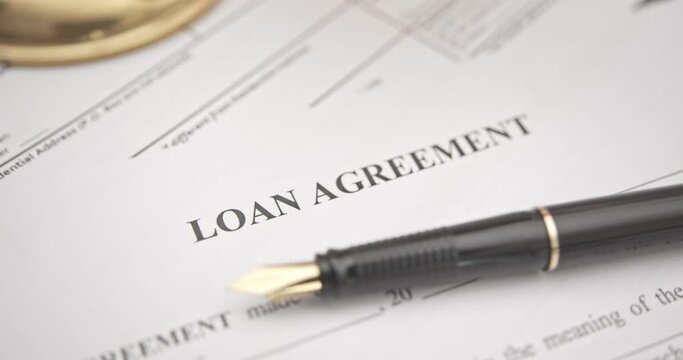 Business loan agreement or legal document concept : Fountain pen on a loan agreement paper form. Loan agreement is a contract between a borrower and a lender, a compilation of various mutual promises.
