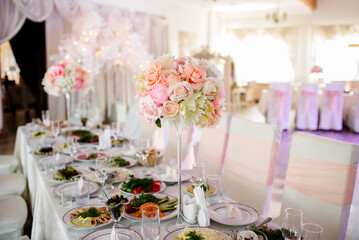 Flower decoration of wedding tables. Banquet table setting and decoration. Cutlery on the table.