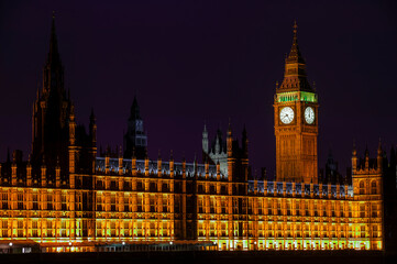 Fototapeta na wymiar Big Ben of the Houses of Parliament London England UK at night striking midnight on new year's eve which is a popular travel destination tourist attraction landmark of the city centre, stock photo