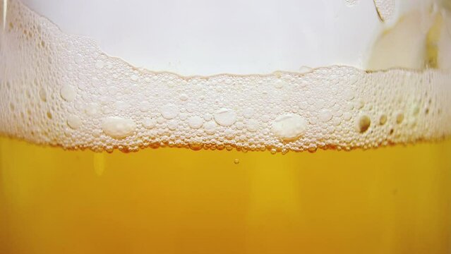 Close-up pull focus of beer bubbles inside a glass - Fast, macro zoom in shot
