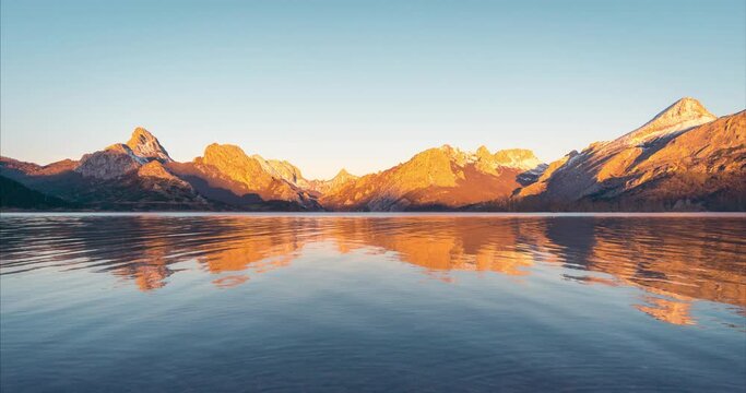 Ria&ntilde;o snowy peak during sunrise reflection in water reservoir. Leon mountain range, Castilla y Le&oacute;n, Spain.