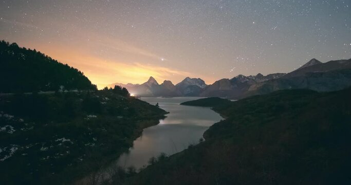 Night timelapse in Ria&ntilde;o reservoir and mountains. Ori&oacute;n and winter milky way setting over peaks