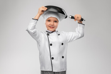 cooking, culinary and profession concept - happy smiling little girl in chef's toque and jacket with frying pan over grey background - obrazy, fototapety, plakaty