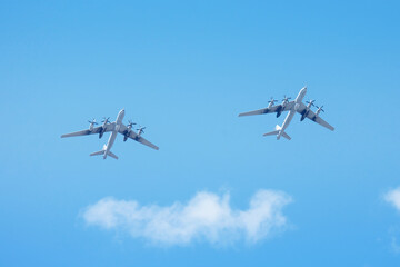 Two military aircraft with turboprop engines in the sky.