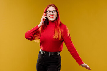 Glamour woman wearing glasses using smartphone on yellow background