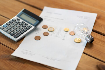 electricity, energy crisis and power consumption concept - close up of utility bill, calculator,...
