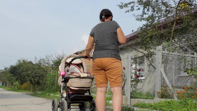 woman with stroller and talking on the phone,woman in shorts with a stroller