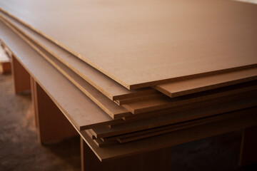 Boards are stacked. Plywood sheet. Joinery. They made furniture production. Building material in garage. Raw wood.