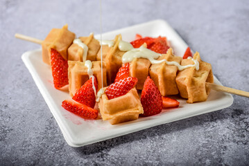 Waffle topped with cream and strawberries 