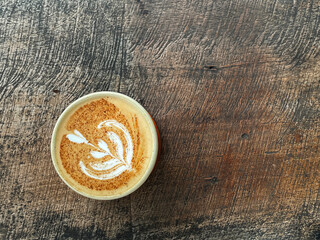 a cup of coffee with a love pattern on a wooden table