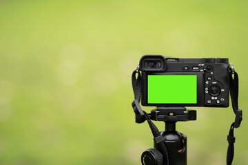 Mirrorless camera with green screen on the monopod . Green screen camera