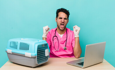 hispanic handsome man shouting aggressively with an angry expression. veterinarian concept