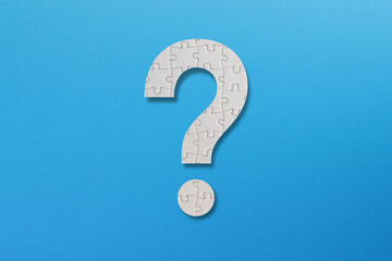 Question mark shaped white jigsaw puzzle on blue background