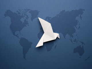 White origami pigeon on a blue paper background, world peace concept