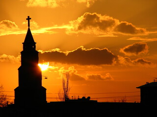 Fototapeta premium A church standing in front of a setting sun