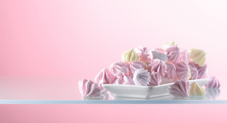 Homemade colorful meringue on a pink background.