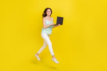 Full body photo of young charming business lady working on new project in netbook isolated on yellow color background