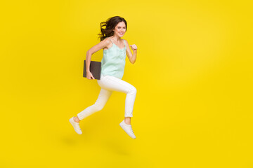 Fototapeta na wymiar Full body photo of energetic positive woman running to work with netbook isolated on yellow color background