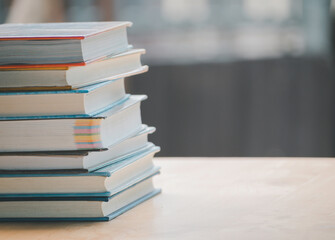 A simple composition of many books, stack or pile of books on wooden table, one of them open with copy space.
