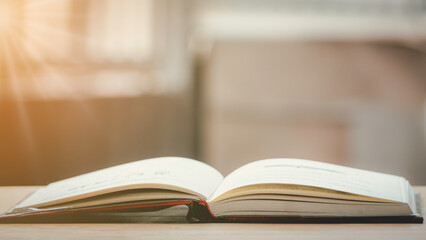 A simple composition of many books, stack or pile of books on wooden table, one of them open with copy space.