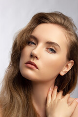 Fototapeta premium Beautiful woman with bright make up eye with sexy black liner makeup. Fashion big arrow shape on woman's eyelid. Natural lips. Chic evening make-up. Blonde long wave hair. Shining face skin