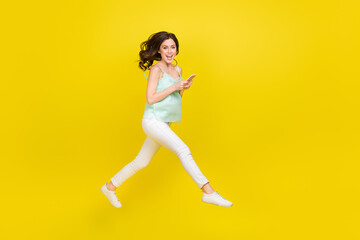 Fototapeta na wymiar Full size profile side photo of overjoyed delighted young female enjoy summer surfing smartphone isolated on yellow color background