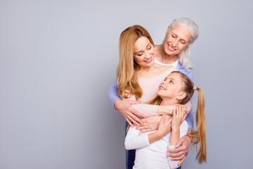 Photo of three cheerful friendly people embrace enjoy each other isolated on grey color background