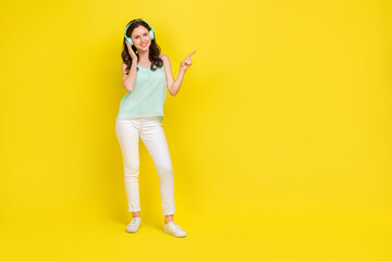 Full body photo of charming stunning lady with headphones recommend her favorite music isolated on yellow color background