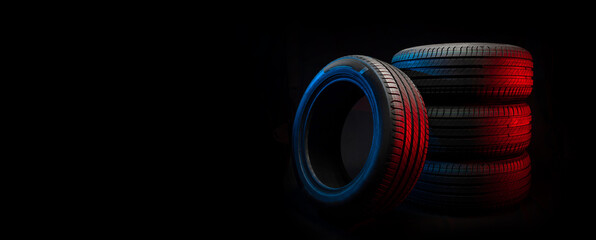 New car tires. Group of road wheels on dark background. Summer Tires with asymmetric tread design. Driving car concept. - obrazy, fototapety, plakaty