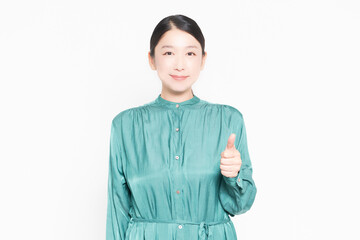 白背景の前で良いねのポーズをする主婦